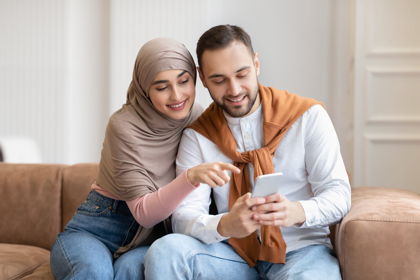 A couple at home checking a transfer on their phone